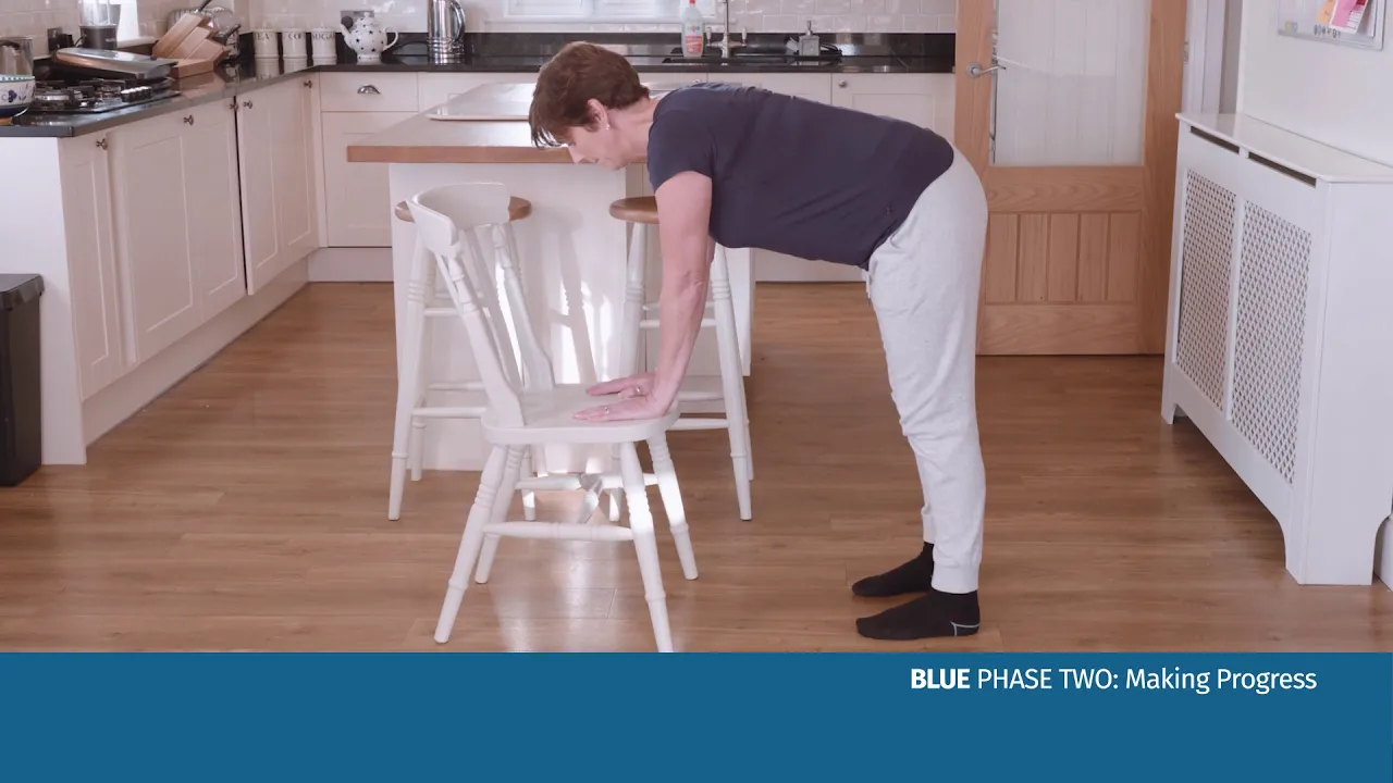 en kvinde, der bøjer sig over en stol