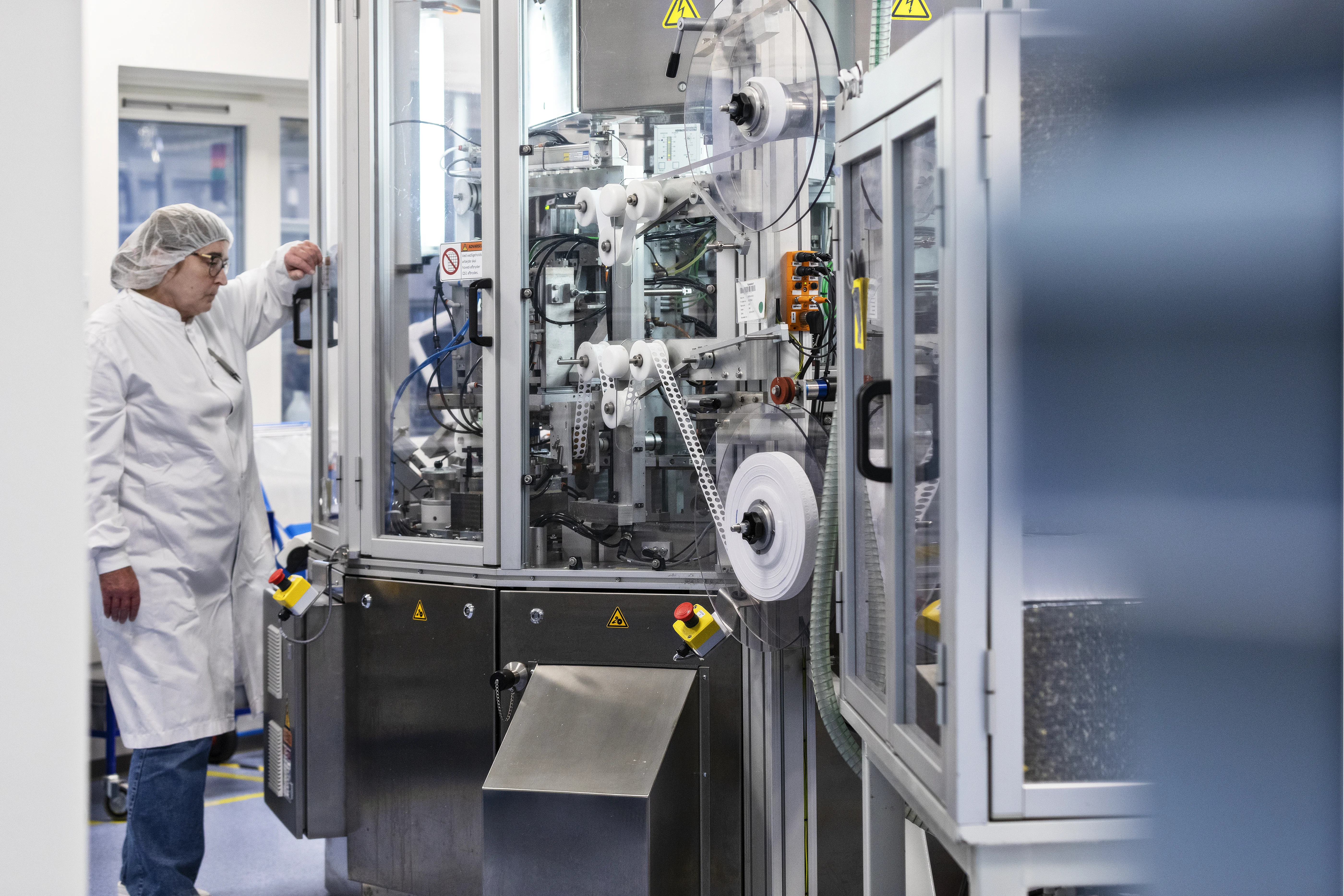 a person in a white coat working in a server room