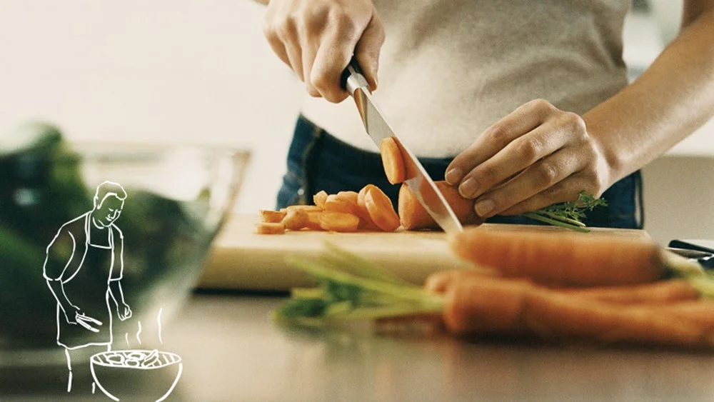 a close-up of a person cutting carrots