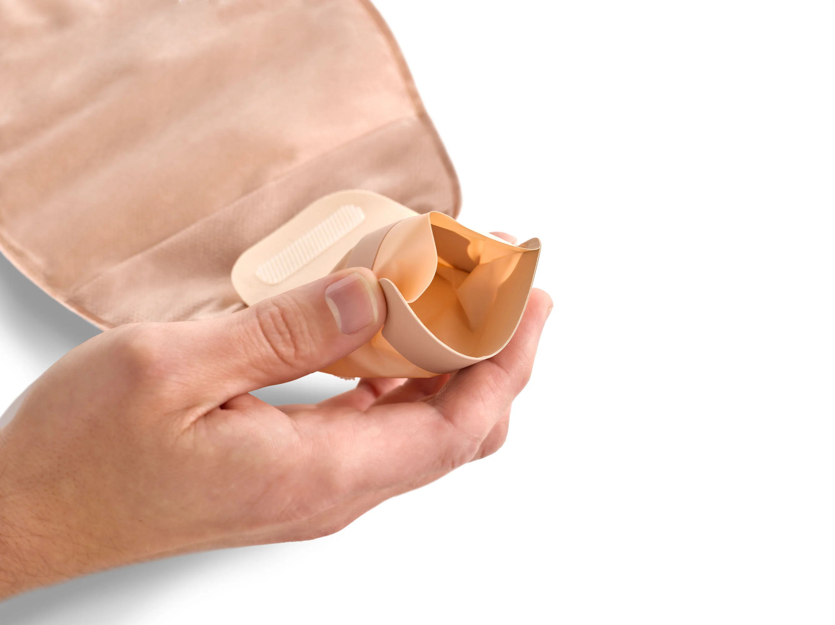 a hand holding a white pill