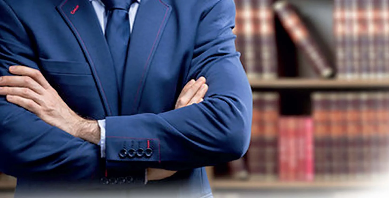 Un uomo in giacca e cravatta con le braccia incrociate