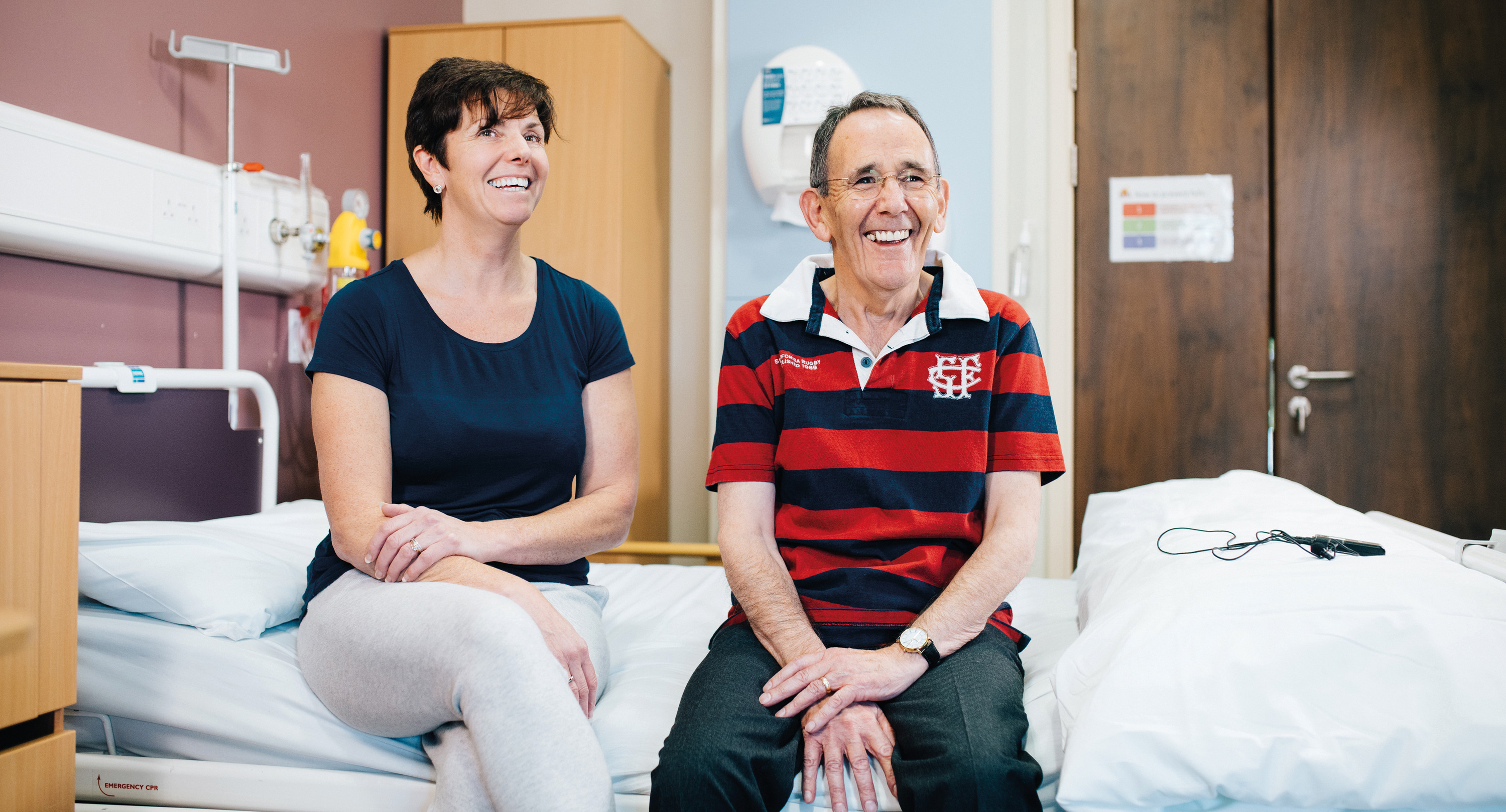a man and a woman sitting on a bed